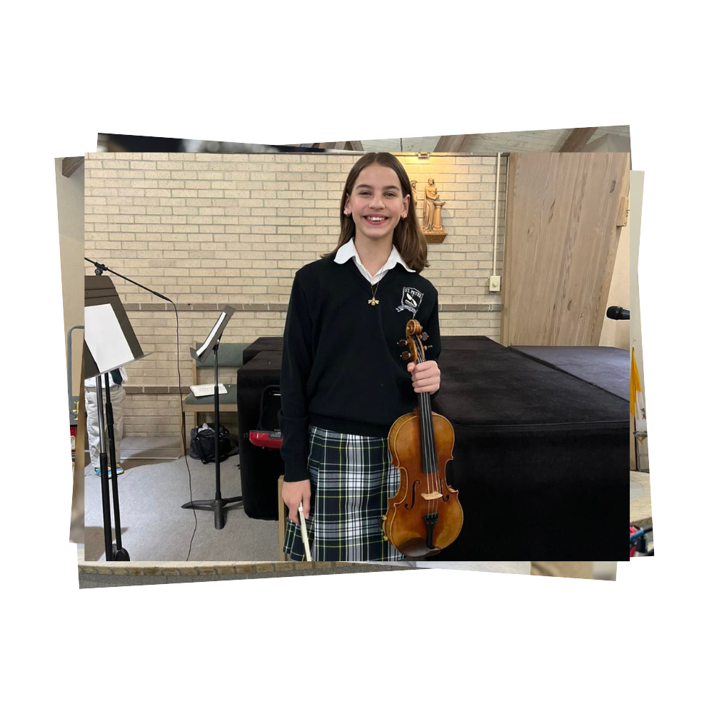 Middle school student smiles as she holds her violin and bow