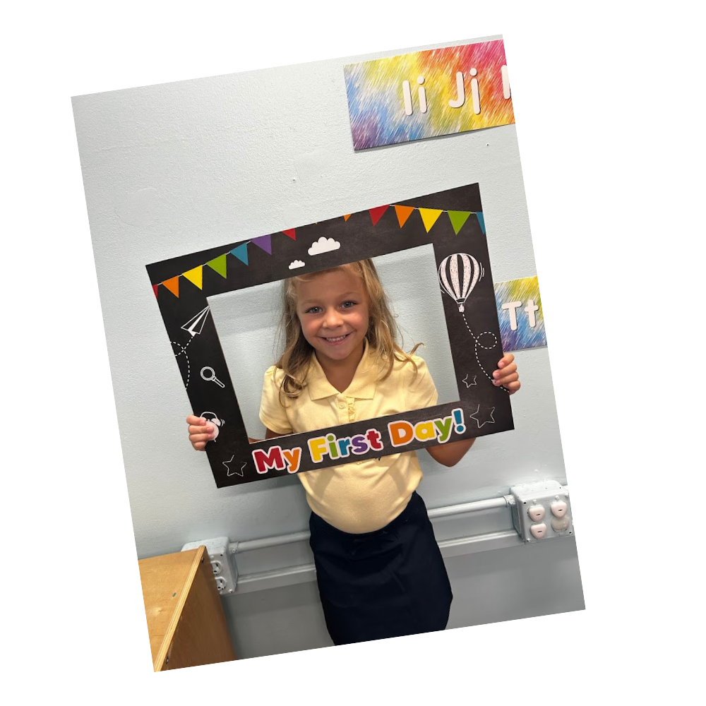 Student holds up frame that reads My First Day