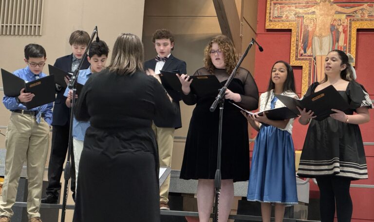 Treble Cat Choir students sing in the Church with their choir director