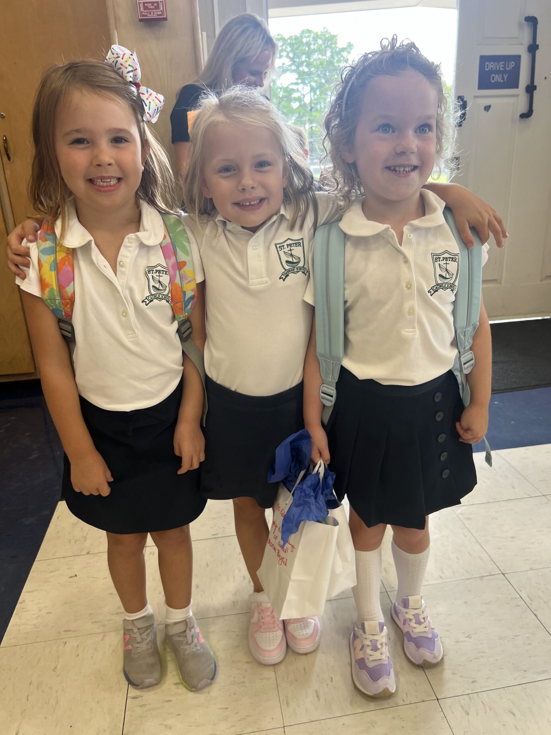Catholic kindergarten students in uniform smiling at camera