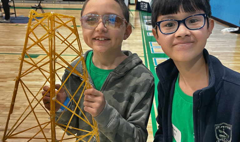 Students hold up science project in science olympiad