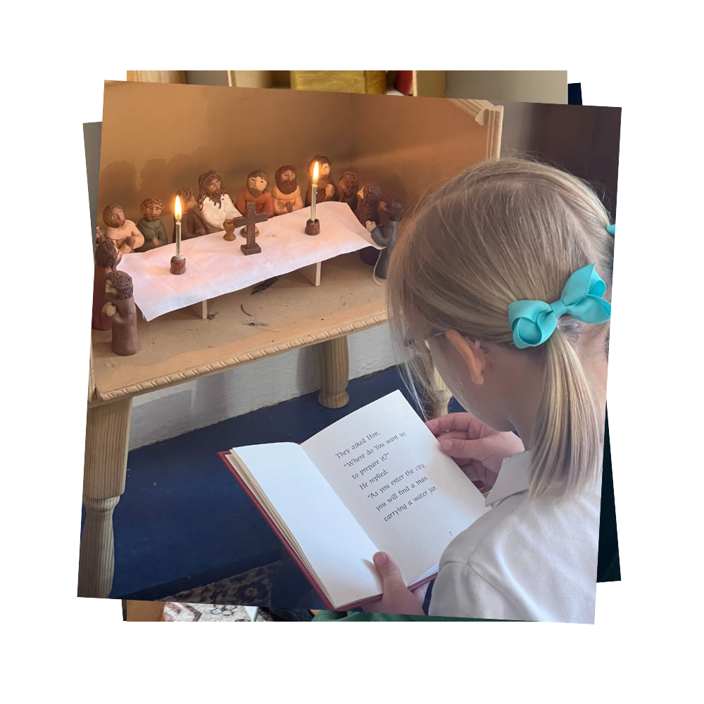 A girl reads a book in front of a set of statues of Jesus and the apostles at the Last Supper