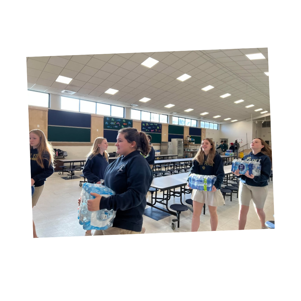 Catholic school students carrying donated cases of water bottles