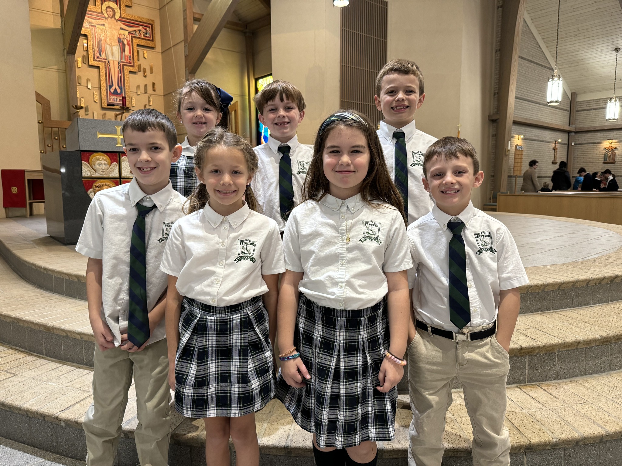 Elementary students smile for a group photo near the Altar after assisting at the Mass as readers