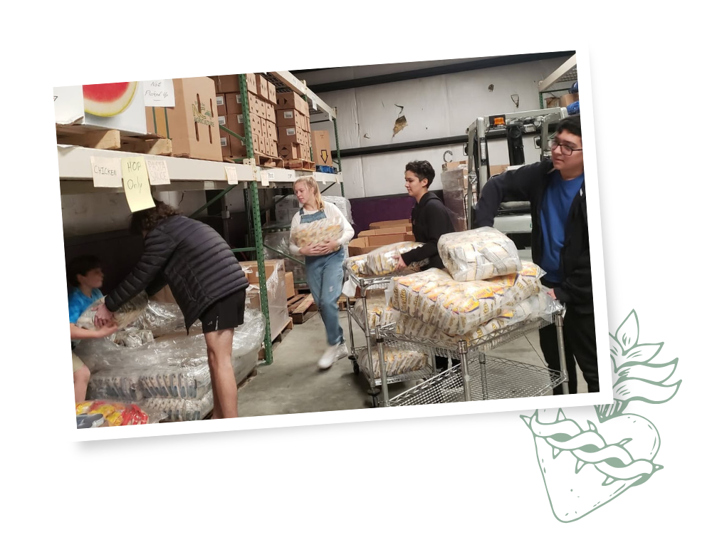 Students loading donated food onto pallets at food distribution center