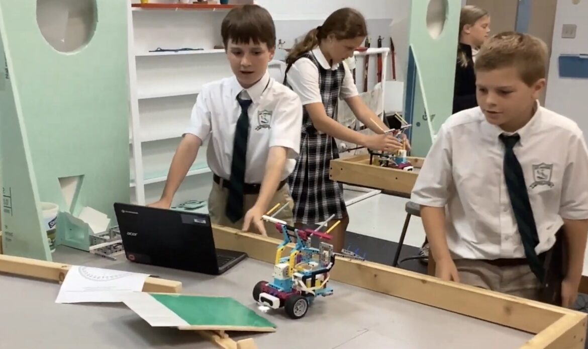 two boys working with a robot