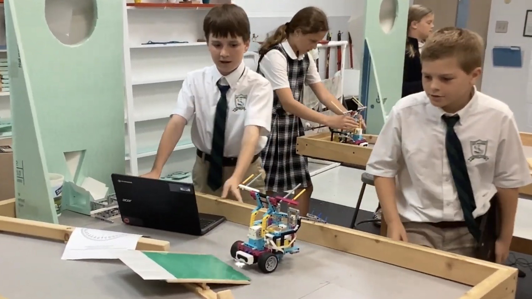two boys working with a robot