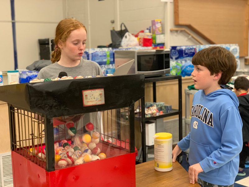 Two home school students in the Home School Association, stand near a bingo machine at a pizza/bingo event